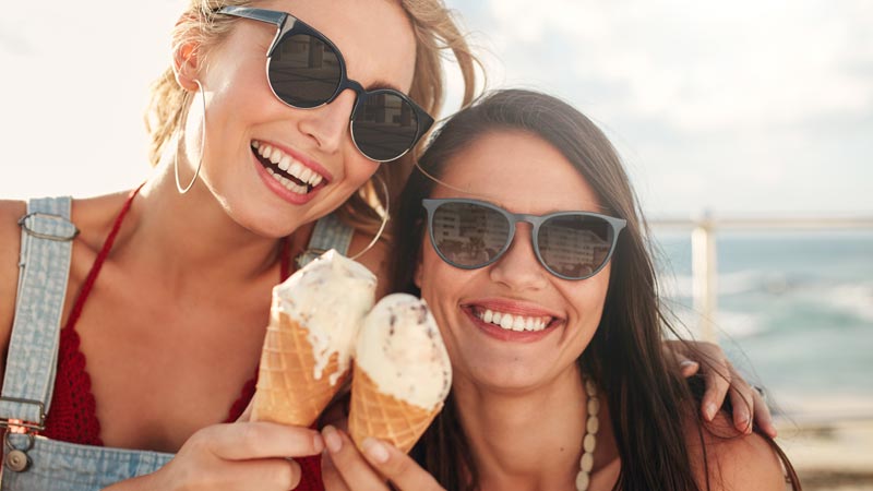 Duas jovens a comer um gelado de cone